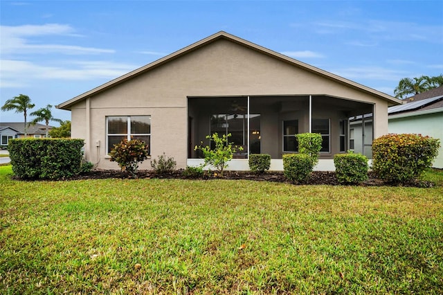 rear view of property with a sunroom and a lawn