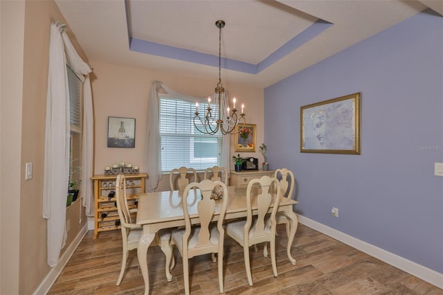 6516 Salt Creek Ave, Apollo Beach, FL 33572 - dining room with a chandelier, wood finished floors, baseboards, and a tray ceiling