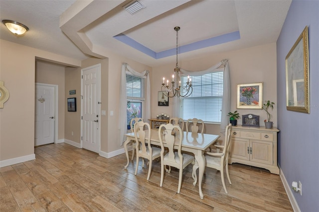 6516 Salt Creek Ave, Apollo Beach, FL 33572 - dining space with a chandelier, light wood-type flooring, a raised ceiling, and baseboards