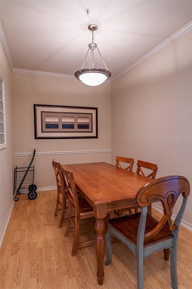 dining space featuring crown molding and light hardwood / wood-style floors