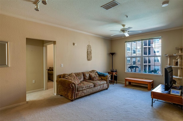 living room featuring ceiling fan, light colored carpet, a textured ceiling, and ornamental molding