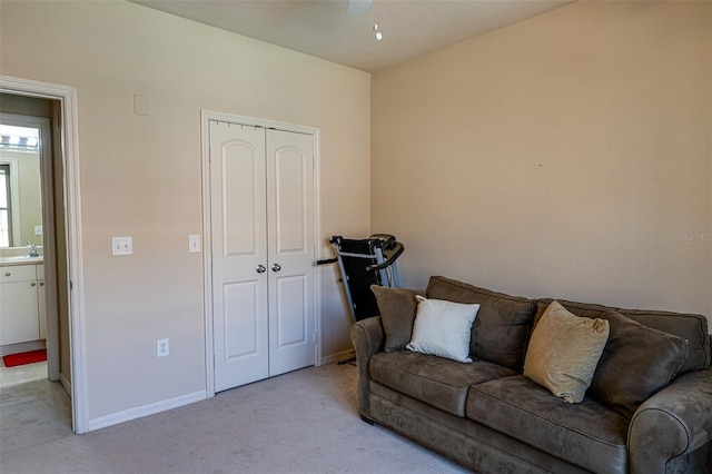 carpeted living room with ceiling fan and sink