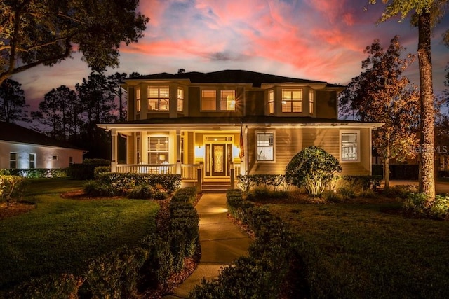 view of front of property featuring covered porch and a lawn