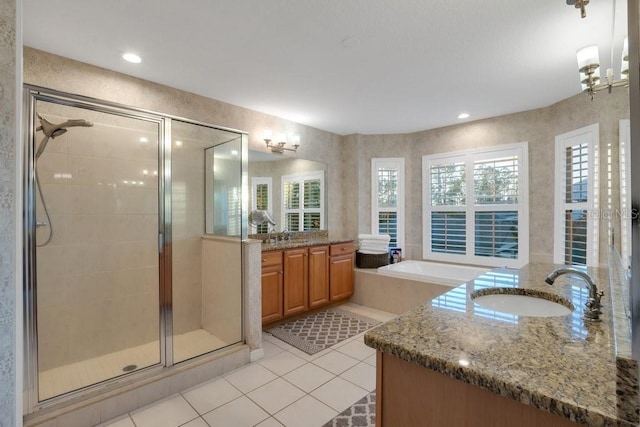 bathroom with tile patterned floors, vanity, independent shower and bath, and a healthy amount of sunlight