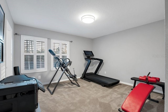 workout area featuring a textured ceiling and light colored carpet