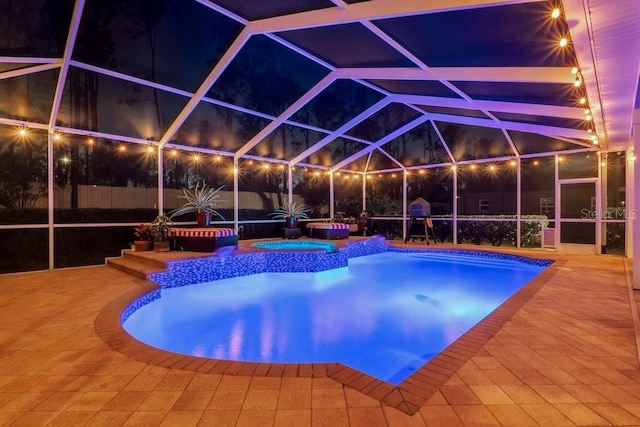 view of pool featuring a lanai, an in ground hot tub, and a patio