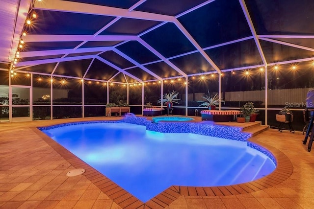 view of pool featuring an in ground hot tub, a patio, and glass enclosure