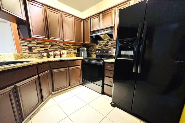 kitchen featuring dark brown cabinetry, black fridge, stainless steel range with electric stovetop, decorative backsplash, and light tile patterned floors