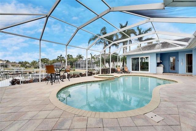 view of pool featuring a water view, a lanai, an in ground hot tub, and a patio