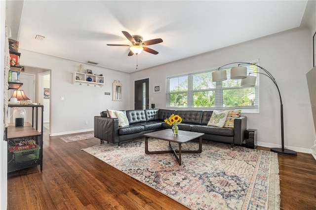 living room featuring visible vents, ceiling fan, baseboards, and wood finished floors