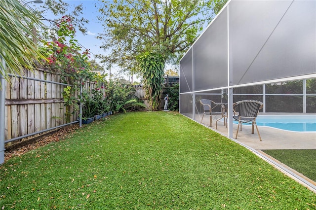 view of yard with glass enclosure, a patio area, a fenced backyard, and a fenced in pool