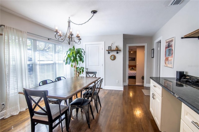 dining area with visible vents, baseboards, an inviting chandelier, and dark wood finished floors