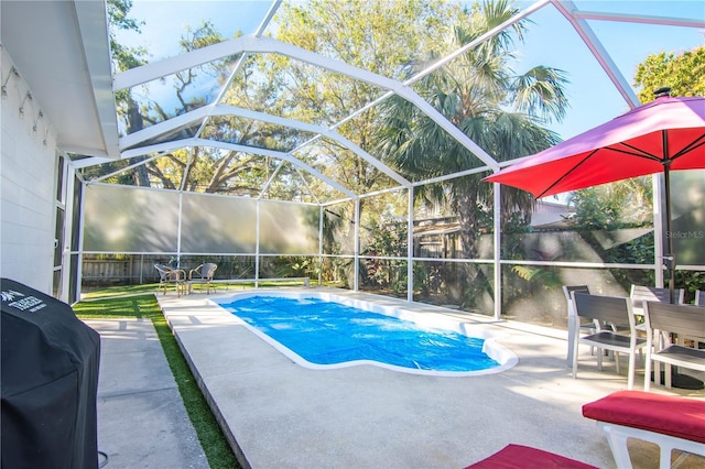 outdoor pool with glass enclosure, a patio area, fence, and grilling area