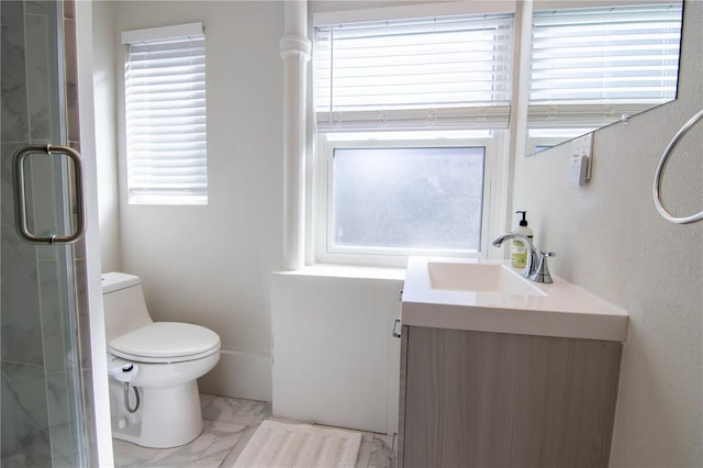 bathroom featuring marble finish floor, a stall shower, vanity, and toilet