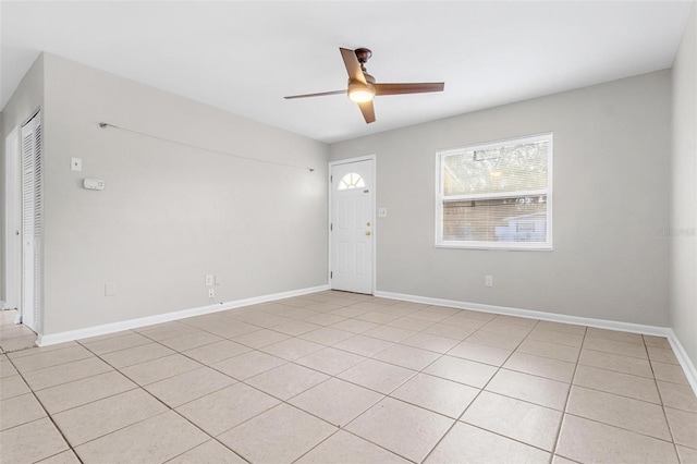 tiled empty room featuring ceiling fan