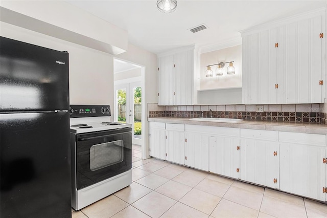 kitchen with black refrigerator, electric range, white cabinetry, and sink