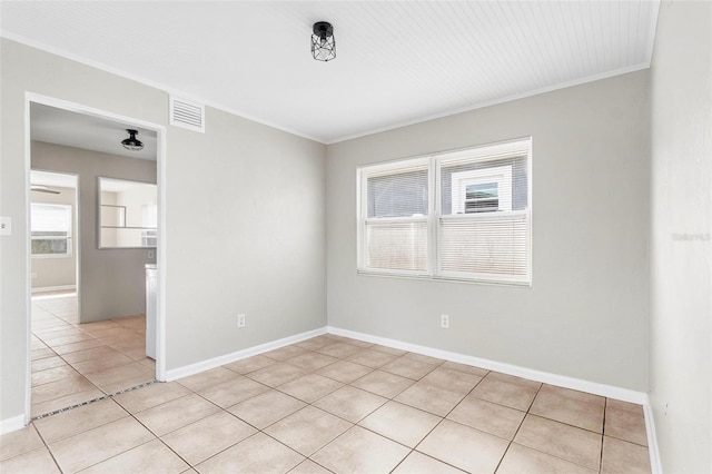 spare room featuring crown molding and light tile patterned floors