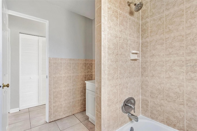 bathroom featuring tile patterned floors, tile walls, vanity, and tiled shower / bath combo