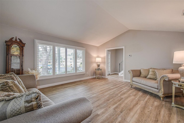 living room with light wood-type flooring and lofted ceiling