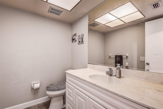 bathroom featuring hardwood / wood-style flooring, vanity, and toilet