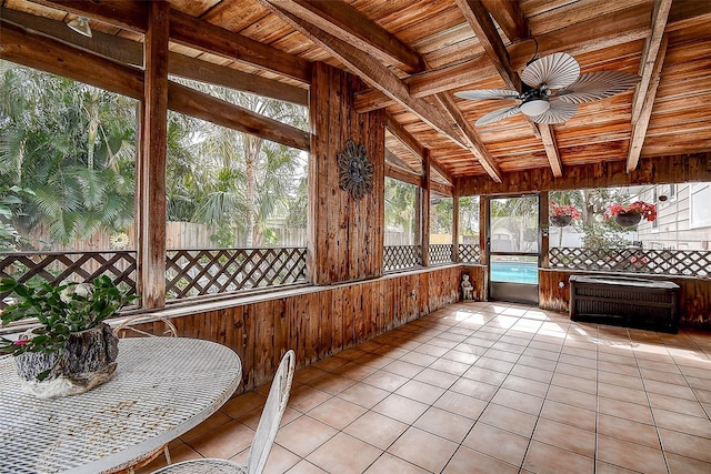 unfurnished sunroom with lofted ceiling with beams, ceiling fan, and wood ceiling