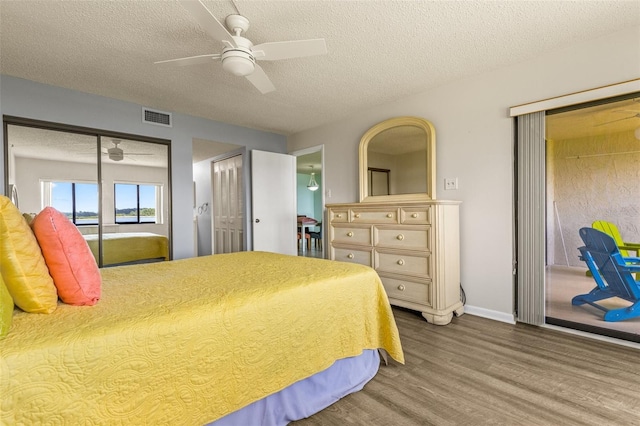 bedroom featuring wood-type flooring, access to outside, ceiling fan, and a textured ceiling