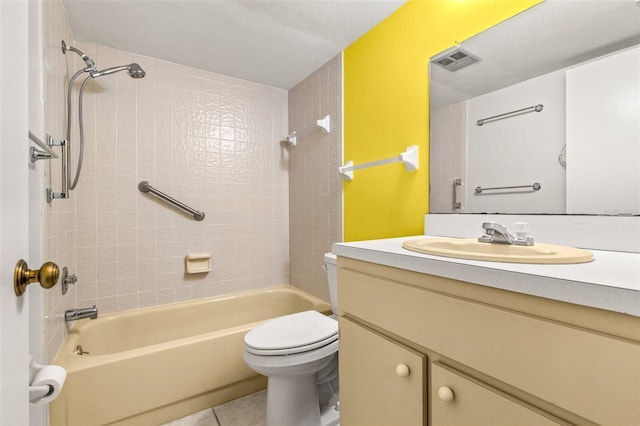 full bathroom featuring tiled shower / bath combo, vanity, and toilet