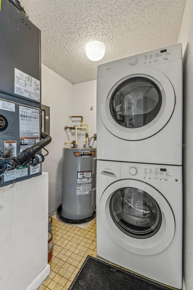 laundry room featuring stacked washer / dryer, a textured ceiling, and water heater