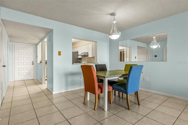 tiled dining area featuring a textured ceiling