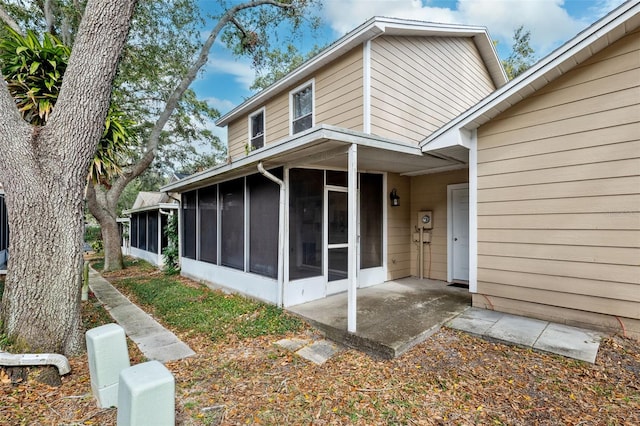 back of property featuring a patio area and a sunroom