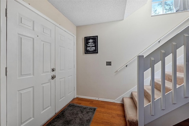 foyer entrance featuring hardwood / wood-style floors and a textured ceiling