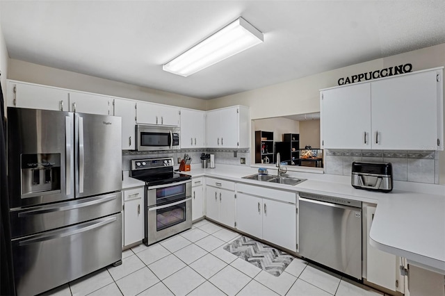 kitchen with backsplash, stainless steel appliances, sink, and white cabinets