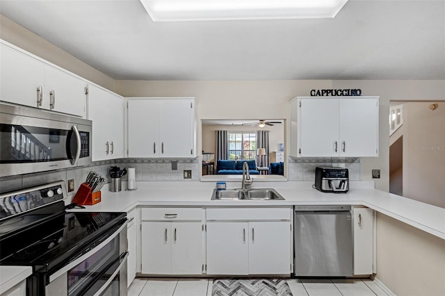 kitchen with white cabinetry, appliances with stainless steel finishes, sink, and decorative backsplash