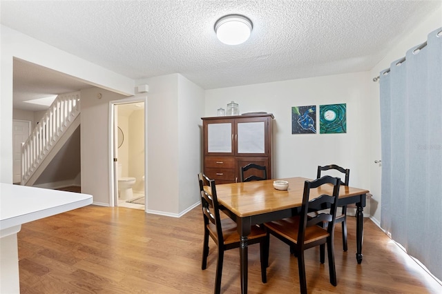 dining room featuring light hardwood / wood-style floors and a textured ceiling