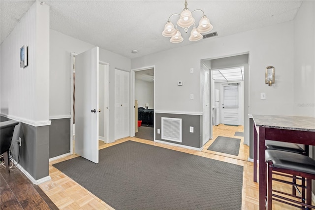 bathroom with parquet flooring, a textured ceiling, and a chandelier