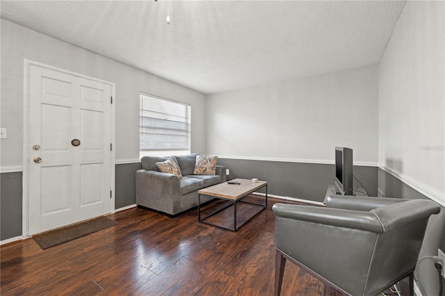 living room with dark hardwood / wood-style floors and a textured ceiling