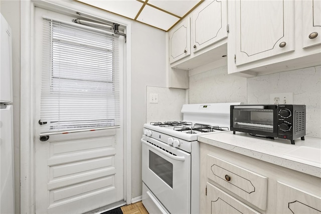 kitchen with light parquet flooring and white gas range