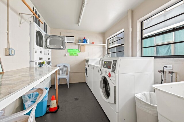 clothes washing area featuring washer and clothes dryer, stacked washing maching and dryer, and sink