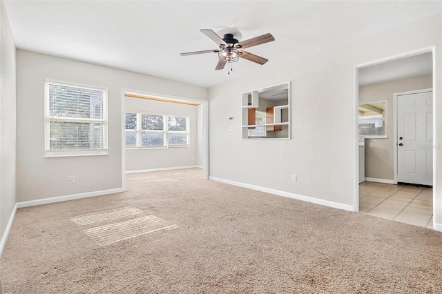 empty room featuring ceiling fan and light colored carpet