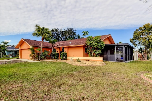 ranch-style home featuring a sunroom, a front lawn, and a garage