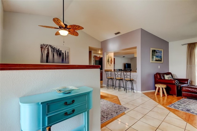 tiled living room featuring ceiling fan and lofted ceiling