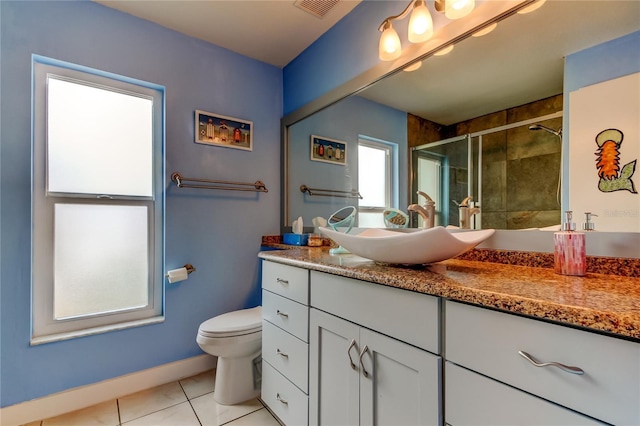 bathroom with tile patterned flooring, vanity, a shower with shower door, and toilet