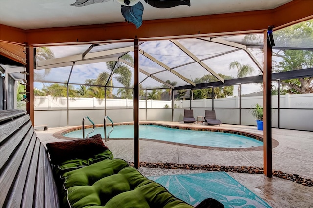 view of pool with glass enclosure, ceiling fan, and a patio