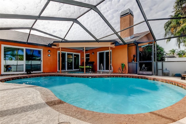 view of pool with ceiling fan, a patio area, and glass enclosure