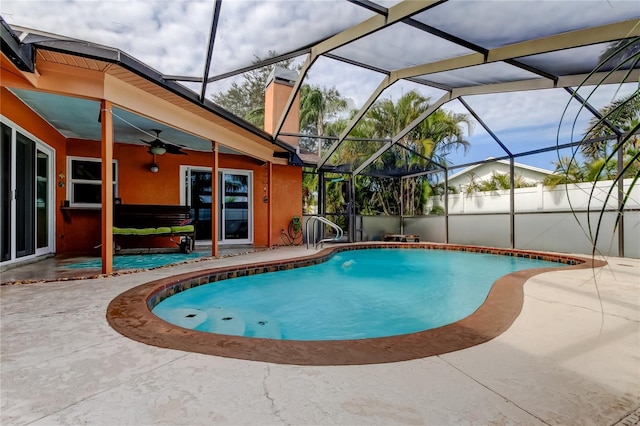 view of pool with a patio area, ceiling fan, and glass enclosure