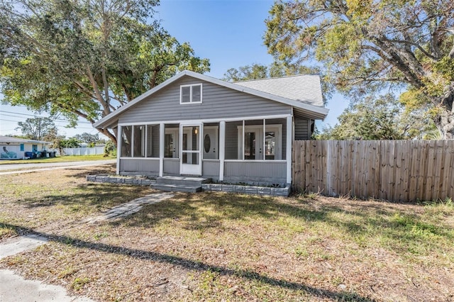 bungalow with a front yard and a sunroom