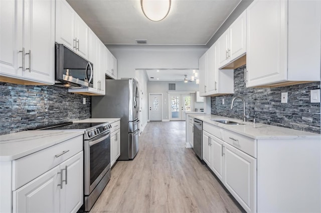 kitchen featuring appliances with stainless steel finishes, white cabinetry, french doors, and light stone counters