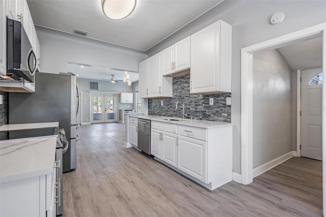 kitchen with ceiling fan, sink, french doors, white cabinets, and appliances with stainless steel finishes