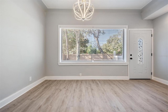 foyer featuring a chandelier, light hardwood / wood-style floors, and plenty of natural light