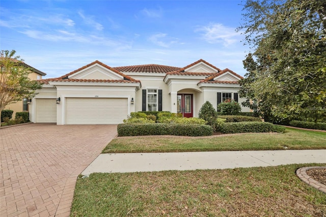 mediterranean / spanish-style house with a front yard and a garage